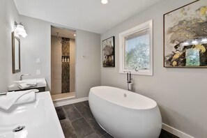 Ein modernes Badezimmer mit einer freistehenden Badewanne, einem großzügigen Waschbecken und einer separaten Duschfläche.