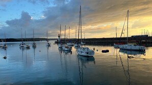 A harbor with multiple sailboats docked, calm water, and a lighthouse in the background. - Apartment 'Les Fougères' with Sea View and Wi-Fi (Erquy)