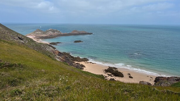 A coastal landscape with a grassy hill, rocky shoreline, and calm sea. - Apartment 'Les Fougères' with Sea View and Wi-Fi (Erquy)