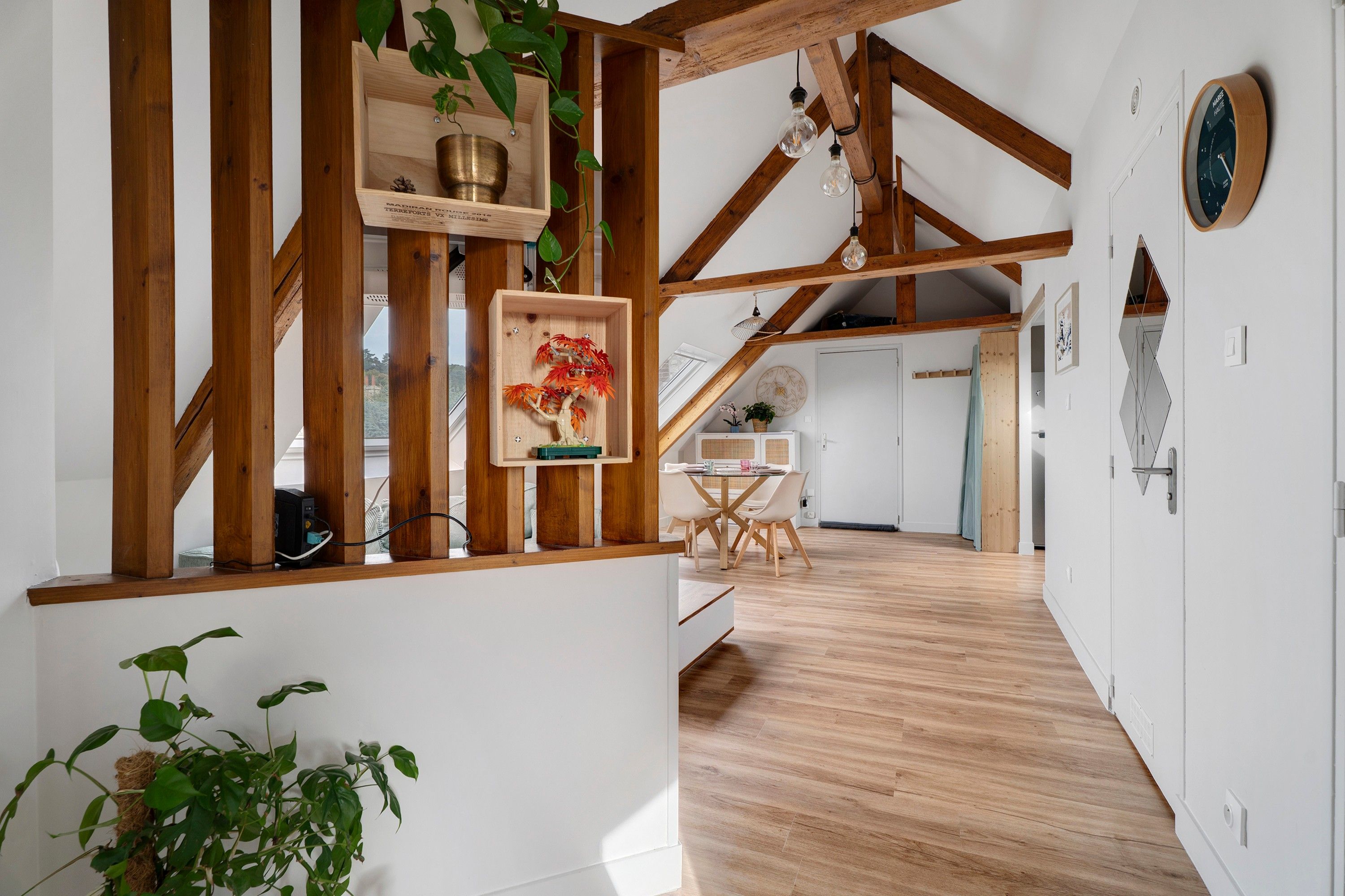 Ein Holzinnenraum mit Treppe, einem Essbereich und einer im Hintergrund sichtbaren Küche.
