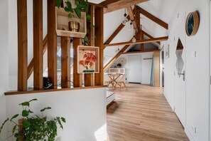 Ein Holzinnenraum mit Treppe, einem Essbereich und einer im Hintergrund sichtbaren Küche.