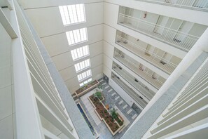 A multi-level atrium with a central courtyard, balconies on each floor, and a modern architectural design. - Cozy apartment near XV de Novembro street in downtown Curitiba. (Curitiba)