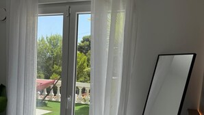 Una habitación con puerta de vidrio corredera, una pizarra y vistas a un jardín.