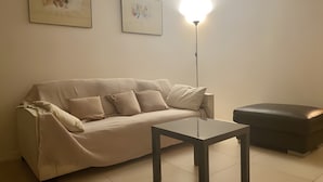 Ein Wohnzimmer mit einer Couch, einem Couchtisch und einer Stehlampe.