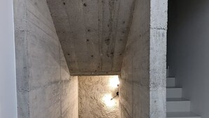 A concrete stairwell with a light fixture at the top and a staircase leading to a landing. - La Maison des Remparts: Private Pool, Wi-Fi, Air Conditioning – Holiday Home in Clérieux (Clérieux)
