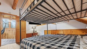 Una habitación con cama, escritorio, silla, hamaca y ventilador de techo.