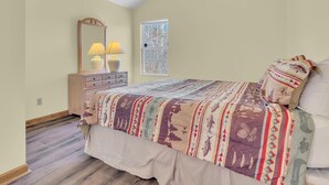 A bedroom with a bed, a dresser, a mirror, two lamps, and a window. - A Family Affair #712 (Gatlinburg)