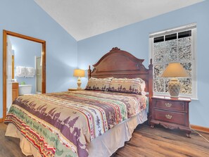 A bedroom with a bed, nightstand, dresser, and a window with a view. - A Family Affair #712 (Gatlinburg)