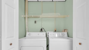 A laundry room with two white washing machines, a drying rack, and a vent. - A Family Affair #712 (Gatlinburg)