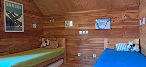 A cabin with two wooden beds, a framed poster, and a painting on the wall. - 104m² wooden chalet in the heart of a preserved regional mountain park (Molines en Queyras)