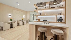 A modern kitchen with a central island, bar stools, and pendant lighting. - 17John: Signature King Studio Apartment (New York)