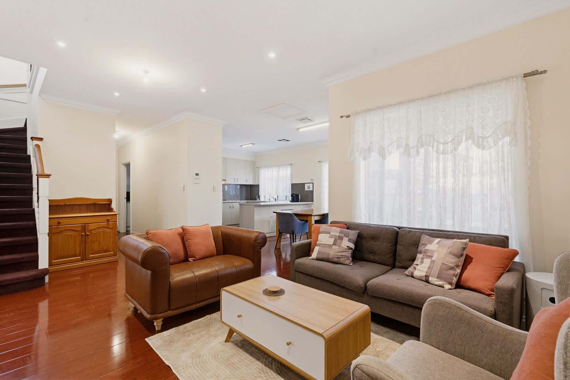 A living room with a sofa, coffee table, and a wooden cabinet.