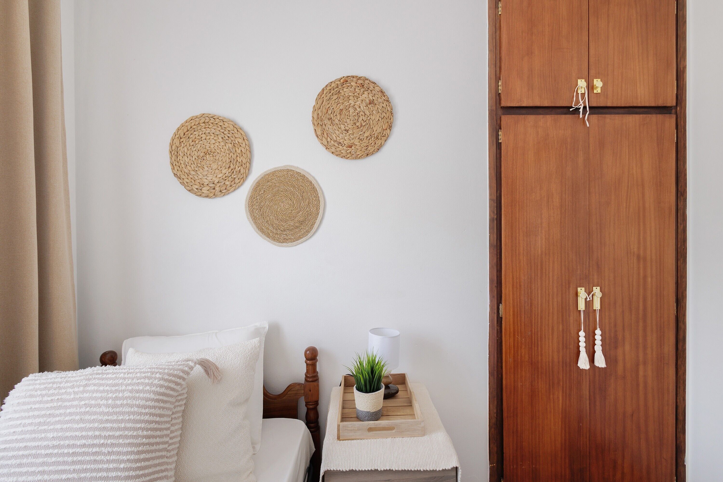 A bedroom with a bed, bedside table, and a wooden wardrobe.