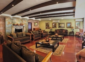 A spacious living room with multiple sofas, a fireplace, and a large painting on the wall. - Luxury ground apartment (Amman)