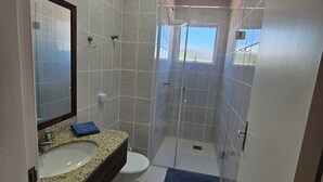 A bathroom with a sink, toilet, and a glass-enclosed shower area. - Penthouse with terrace (Florianópolis)