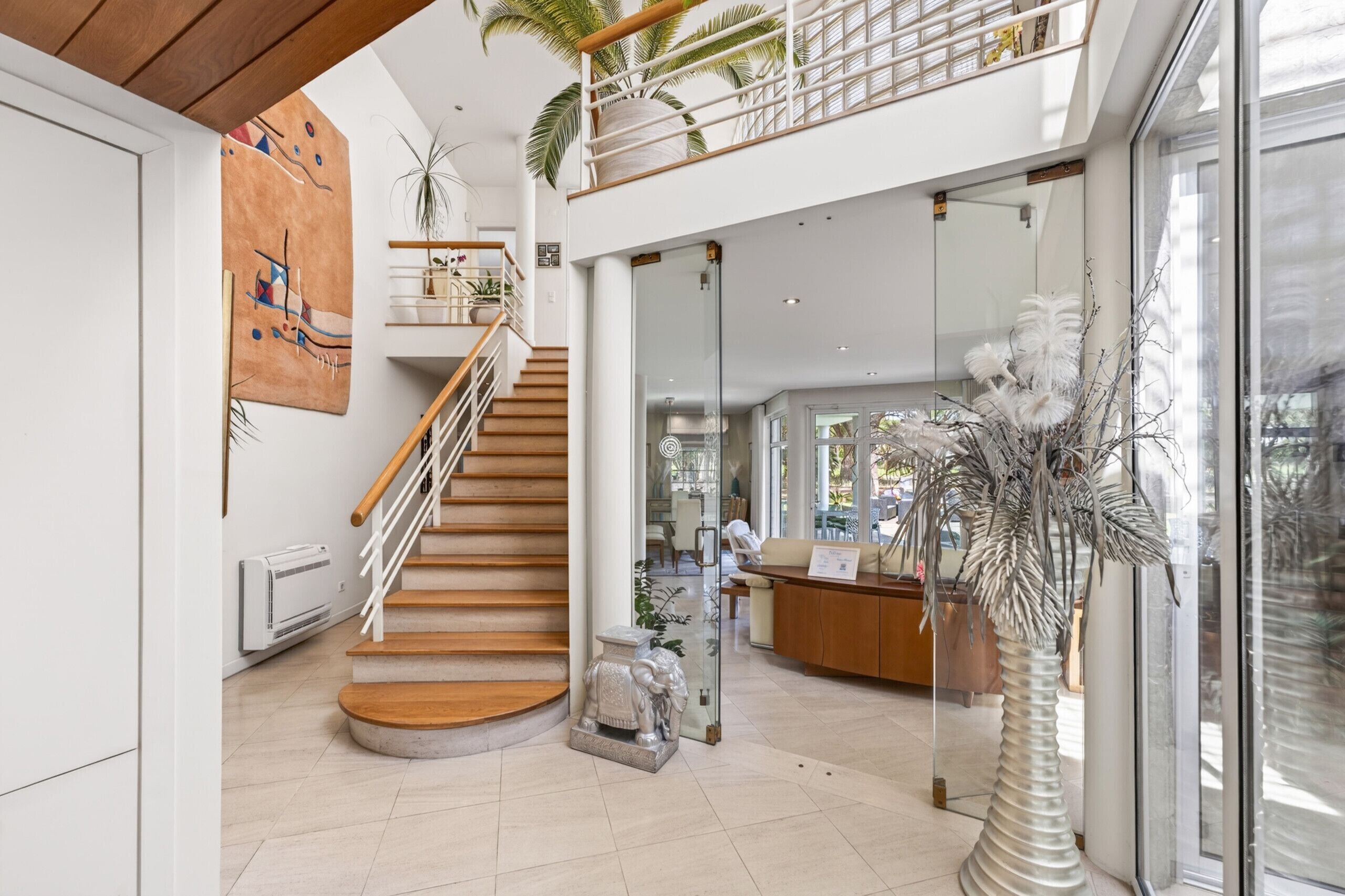 Ein modernes Interieur mit einer Treppe, einem Empfangsbereich und einem großen Fenster.