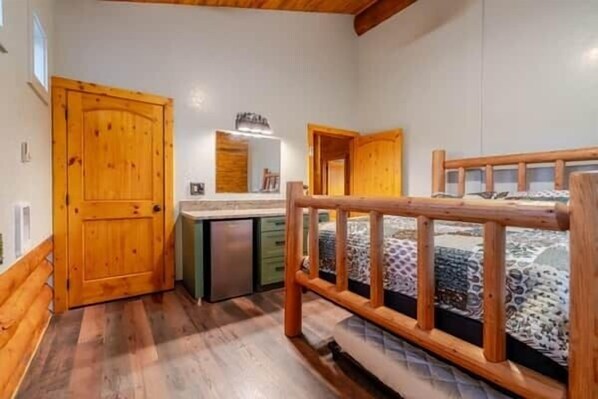 A bedroom with a wooden bed frame, a bedside table, and a built-in wardrobe.