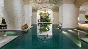 A pool area with a clear view of the pool, a plant, and a bench. - MBH | Panoramic Room (Diso Spongano)
