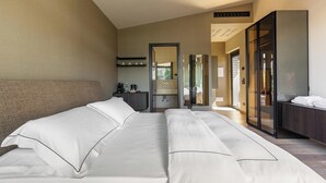 A hotel room with a large bed, a desk, a mirror, and a wardrobe. - MBH | Panoramic Room (Diso Spongano)