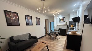 Uma sala de estar moderna com sofá, mesa de centro e área de jantar com cadeiras e mesa.