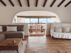 Un accogliente soggiorno con divano, tavolino e zona pranzo con tavolo e sedie.
