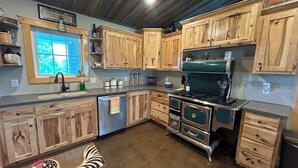 A kitchen with wooden cabinets, a stainless steel stove, and a window with a view.