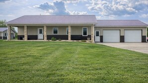 A two-story building with a covered porch, a garage, and a well-maintained lawn.