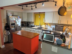 A kitchen with a refrigerator, microwave, coffee maker, and a toaster. - Spacious Shawnee Home - Fenced Yard - Pets Welcome - Sleeps 8 (Shawnee)