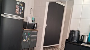 A kitchen with a black refrigerator, a microwave, a coffee maker, and a gas stove. - Prainha, Rio de Janeiro (Rio de Janeiro)