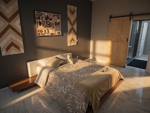 Un dormitorio con una cama, un banco de madera y una puerta corredera.
