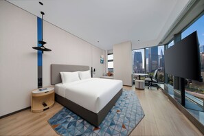 A modern hotel room with a large bed, a desk, and a city view. - Holiday Inn Express Shenzhen Bay By Ihg (Shenzhen)