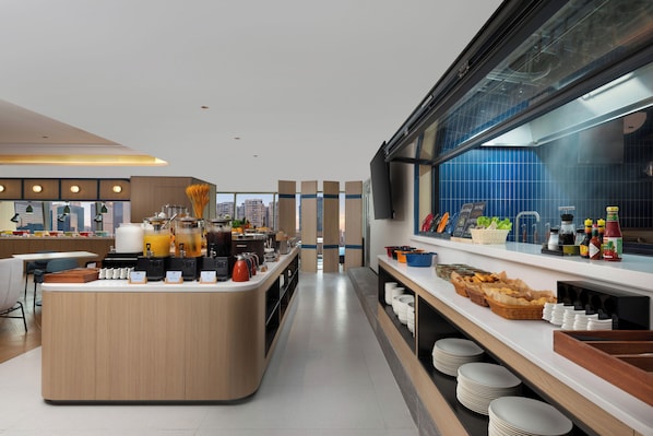 A modern hotel breakfast area with a central island, buffet setup, and a view of the cityscape. - Holiday Inn Express Shenzhen Bay By Ihg (Shenzhen)