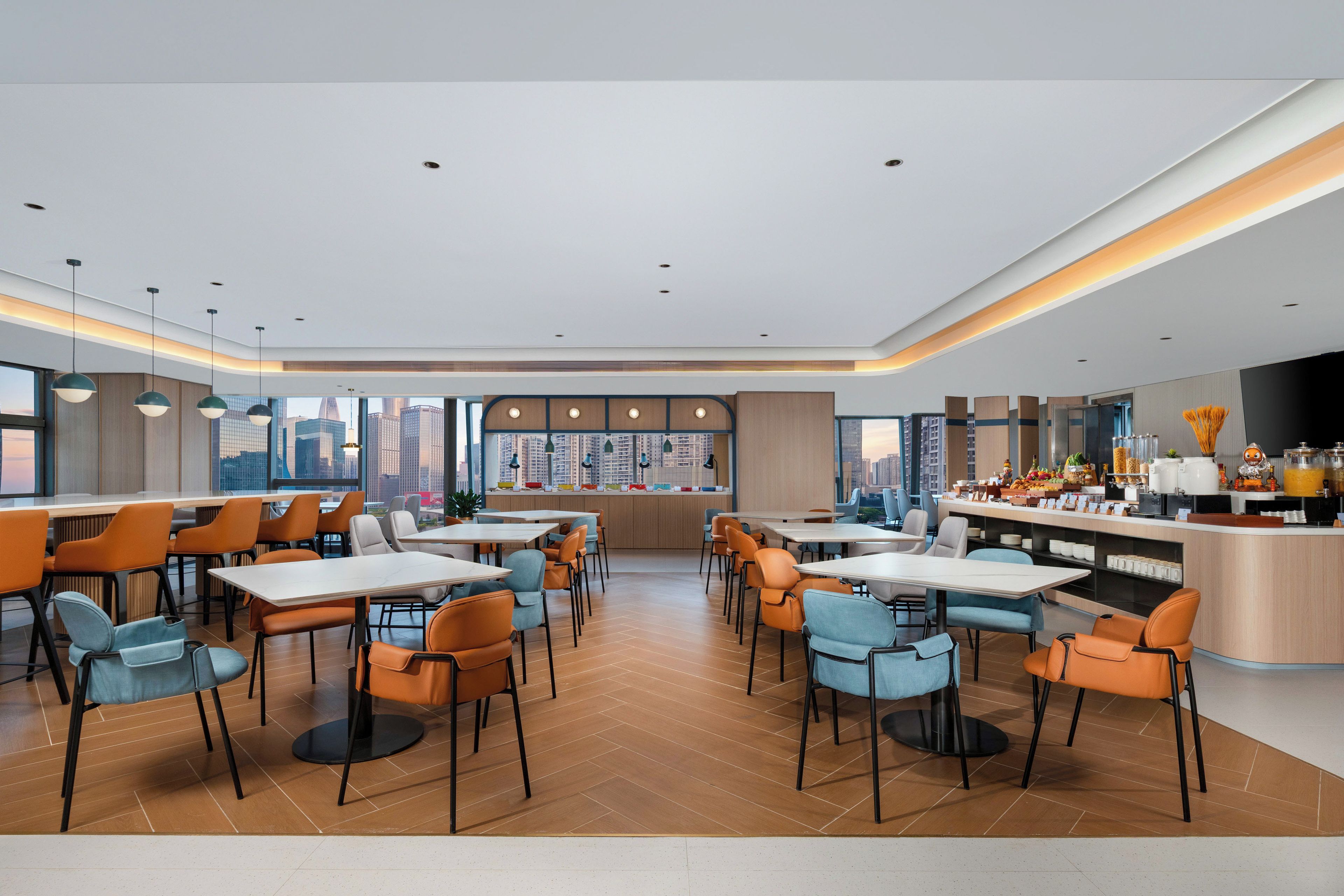 Een modern restaurant met een bar, verschillende zitplaatsen en uitzicht op de skyline.