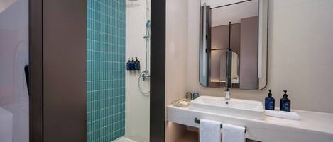 A modern bathroom with a shower, a sink, and a mirror.