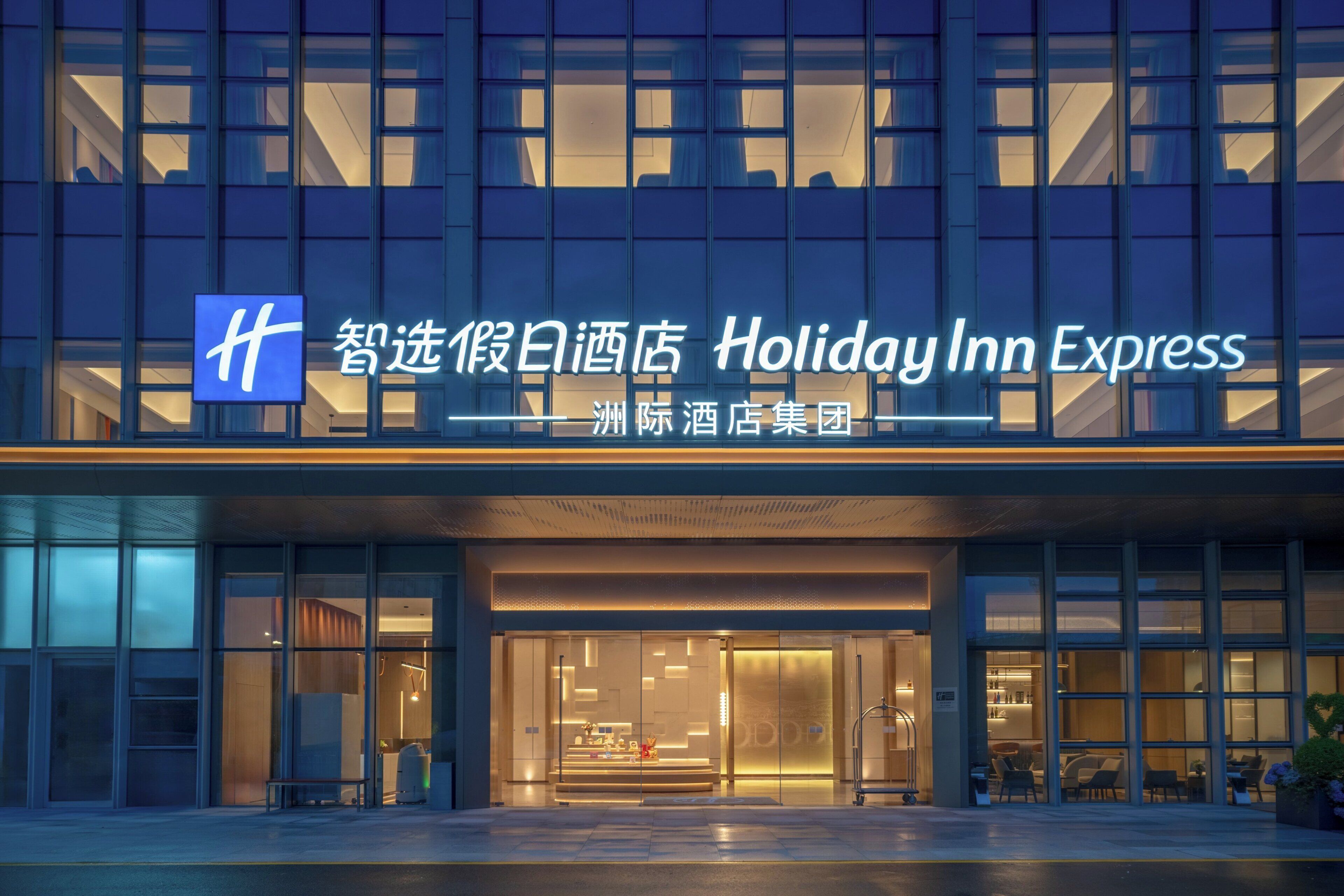 Een Holiday Inn Express gebouw met een moderne gevel, grote glasramen en een opvallende entree.