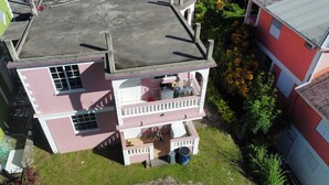 Un immeuble à plusieurs étages doté de balcons, d’un espace buanderie et d’un petit jardin.