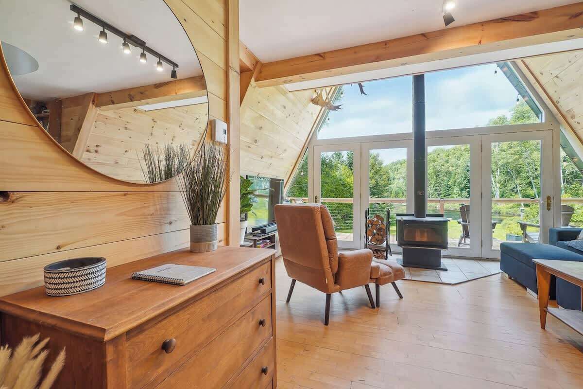 A modern interior with a wooden desk, a comfortable chair, a sofa, and a fireplace.