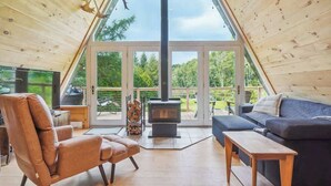 Un salon chaleureux avec un canapé, un fauteuil, une table en bois et une cheminée.