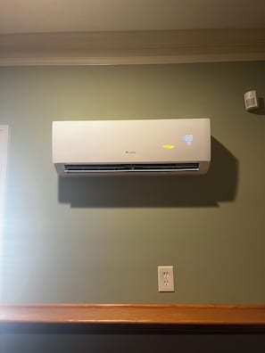 A GREE air conditioning unit mounted on a wall with a light switch and electrical outlet below it. - Perfect studio for FIFA World Cup in Atlanta only 10 minutes from Stadium (Atlanta)