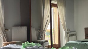 A room with a bed, a chair, and a window with curtains. - Adige View Suite (Verona)