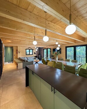 A spacious kitchen with a long island, wooden ceiling, and pendant lighting. - Cosy chalet with jacuzzi for 11 (Bonnevaux)