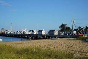 A beach with a pier, houses, and boats. - Can't be beat location steps from the ferry, 2-BR Commercial St condo (Provincetown)