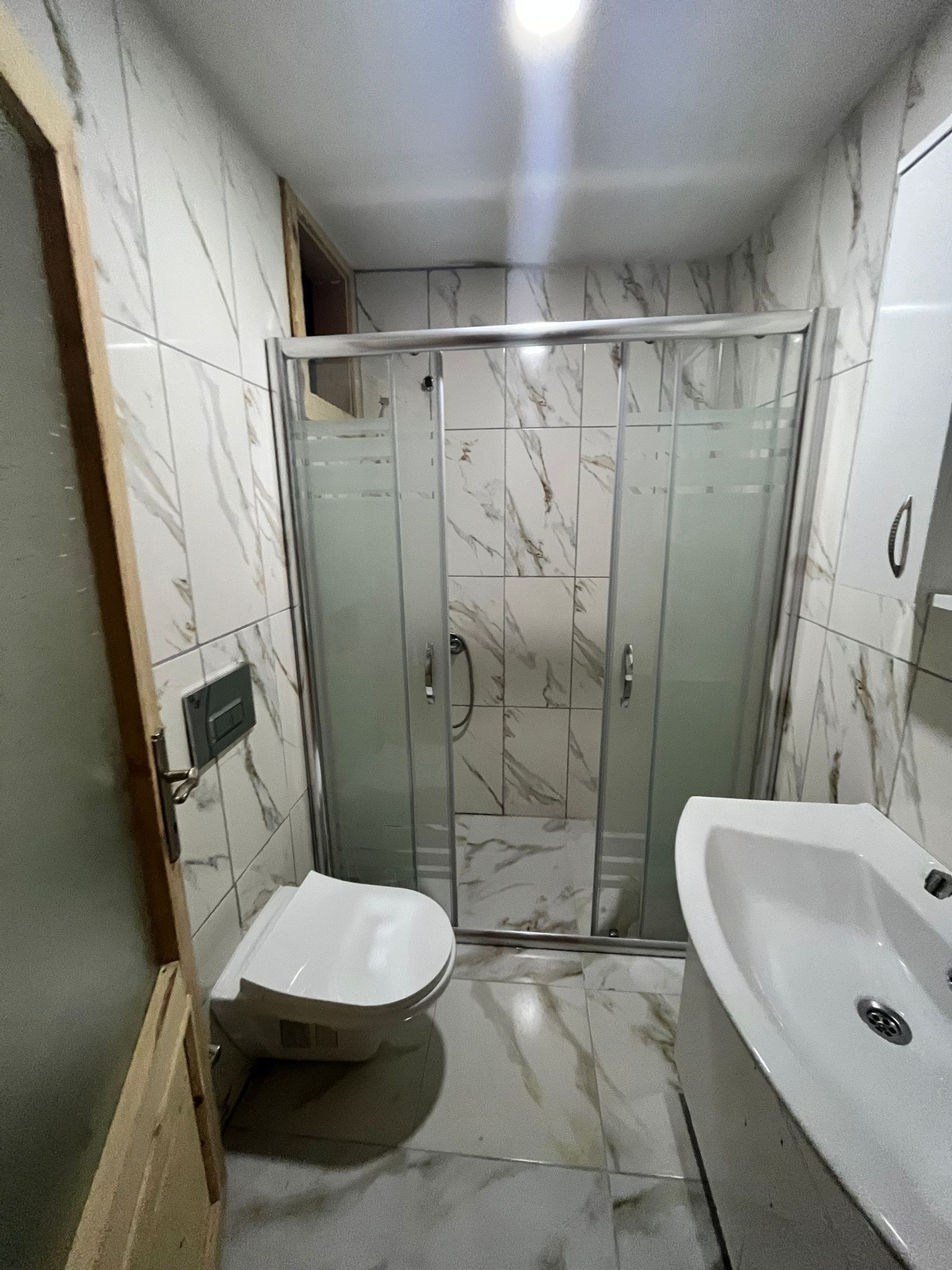 A bathroom with a shower enclosure, a toilet, and a bathtub.