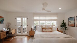 A bedroom with a bed, a desk, a chair, a plant, and a window. - š Designer Bird Rock Gem | Walk to Beach & Cafe (La Jolla)