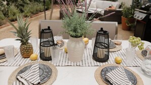 A table set outdoors with a pineapple, candles, and a potted plant. - š Designer Bird Rock Gem | Walk to Beach & Cafe (La Jolla)