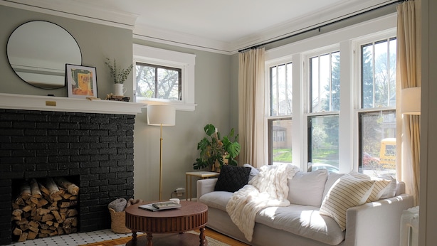 A living room with a fireplace, a sofa, a coffee table, and a window with curtains. - 4BR Hygge Home | Theater + Game Room | Sleeps 10 (Minneapolis)