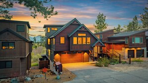 A modern multi-story house with a garage, a staircase leading to the upper floor, and a driveway. - 7 bedroom Luxury by the Lake (South Lake Tahoe)