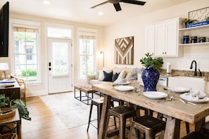 A kitchen with a wooden island, white cabinets, and a ceiling fan. - Boardwalk Blue in Carlton Landing (Carlton Landing)