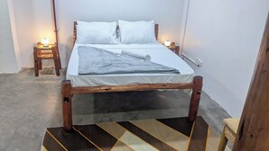 A single bed with a wooden frame, white bedding, and two bedside lamps. - The Hub Train House Amazing Gents Code (Zanzibar Town)