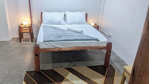 A single bed with a wooden frame, white bedding, and two bedside lamps. - The Hub Train House Amazing Gents Code (Zanzibar Town)